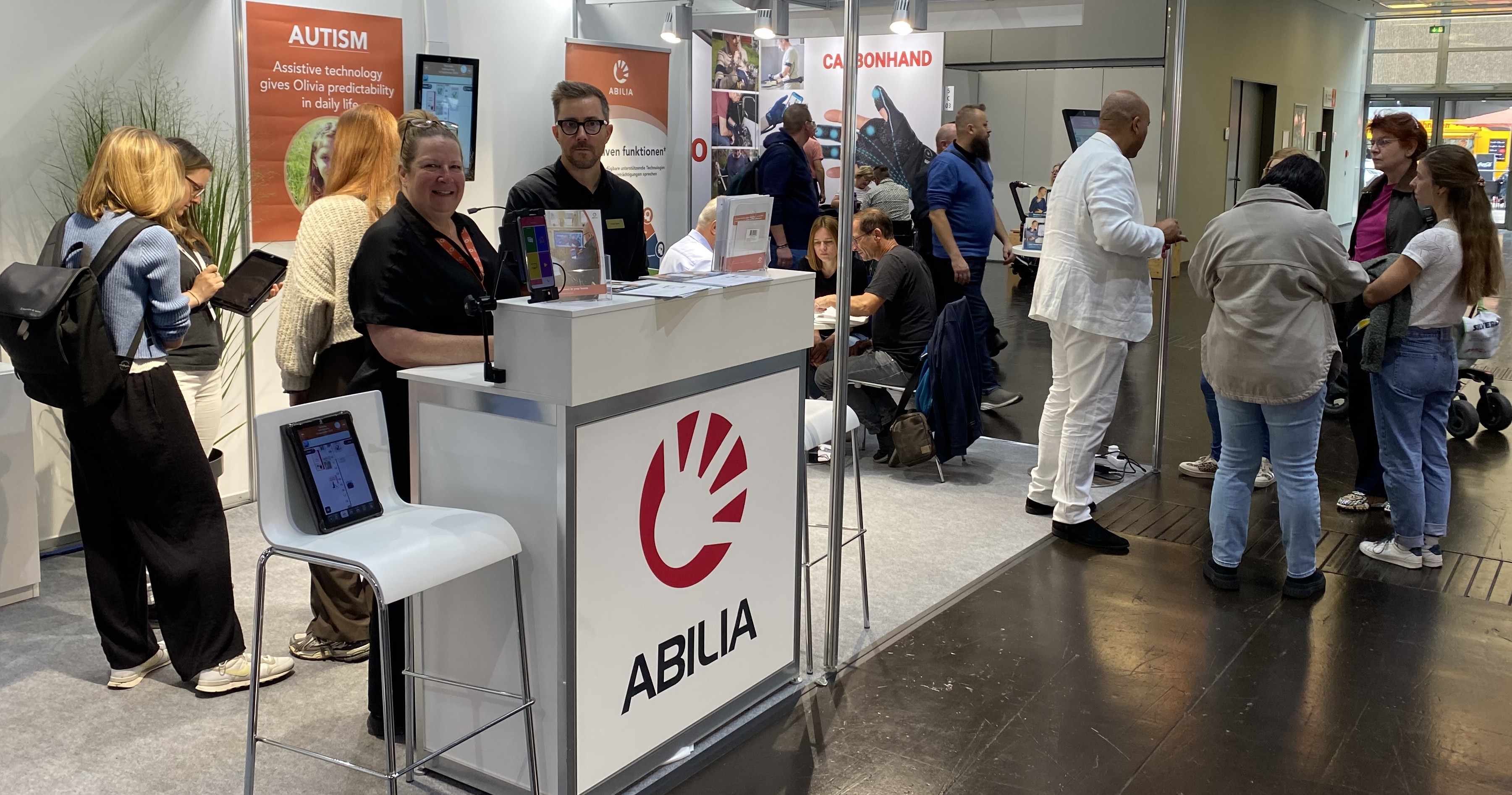 Exhibition stand with stand staff smiling a many visitors