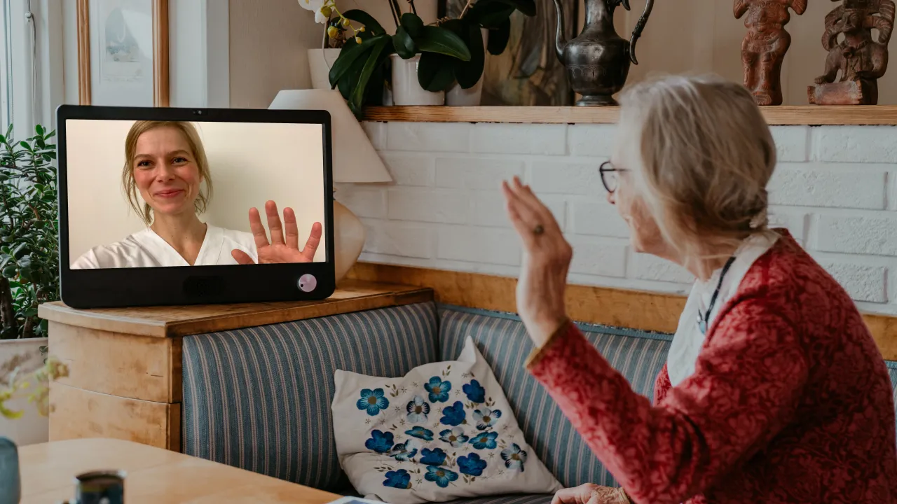 komp pro kvinna som vinkar till anhörig i samtal