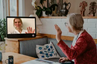 komp pro kvinna som vinkar till anhörig i samtal