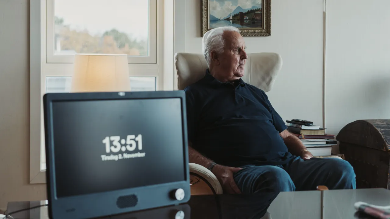 man in chair and clock standing on a table 